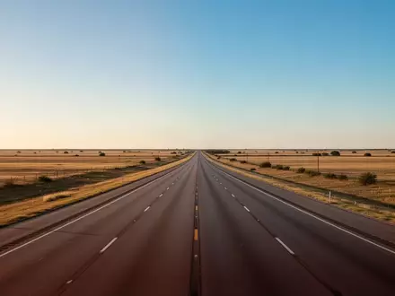 Eine leere, weite Autobahn in der texanischen Landschaft bei Sonnenuntergang, die einen Logistikkorridor symbolisiert. - Foto: über boerse-global.de