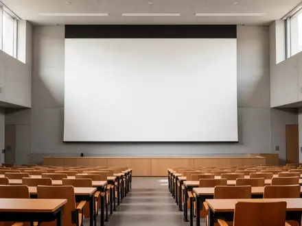 Ein leerer, modern gestalteter Hörsaal in einer Universität mit einer leeren Projektionsfläche und natürlichem Lichteinfall. - Foto: über boerse-global.de