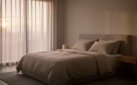 Ein minimalistisch eingerichtetes, ruhiges Schlafzimmer bei Tagesanbruch mit sanftem, natürlichem Licht. - Foto: über boerse-global.de