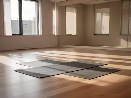 Ein minimalistischer Fitnessraum mit hellem Holzboden und einer einzelnen Yogamatte im hellen Tageslicht. - Foto: über boerse-global.de