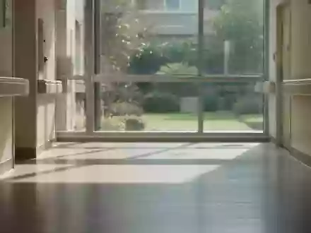 Ein ruhiger, moderner Krankenhausflur mit sanftem Tageslicht und Blick auf einen grünen Innenhof. - Foto: über boerse-global.de