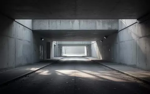 Ein leerer, grauer Beton-Unterführungsgang mit minimalistischer Architektur bei kühlem Tageslicht. - Foto: über boerse-global.de