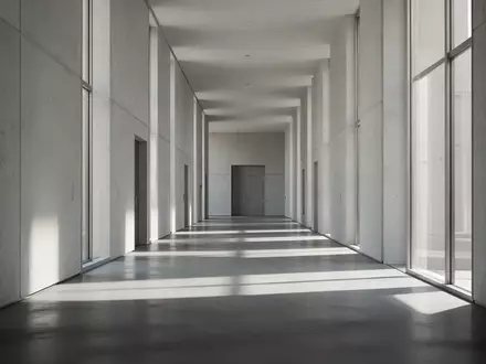Ein leerer, architektonisch minimalistischer Flur in einem öffentlichen Gebäude bei natürlichem Lichteinfall. - Foto: über boerse-global.de