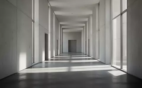 Ein leerer, architektonisch minimalistischer Flur in einem öffentlichen Gebäude bei natürlichem Lichteinfall. - Foto: über boerse-global.de