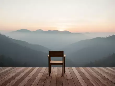 Eine minimalistische Holzterrasse mit Blick auf ein nebliges Gebirge bei Sonnenaufgang, die Stille und Erholung vermittelt. - Foto: über boerse-global.de