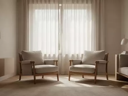 Ein ruhiger, sonnendurchfluteter Wohnraum mit einem leeren Sessel vor einem Fenster, der eine friedliche häusliche Atmosphäre vermittelt. - Foto: über boerse-global.de