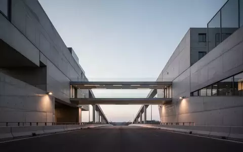 Minimalistische Architektur mit zwei durch eine Brücke verbundenen Gebäuden in der Abenddämmerung. - Foto: über boerse-global.de
