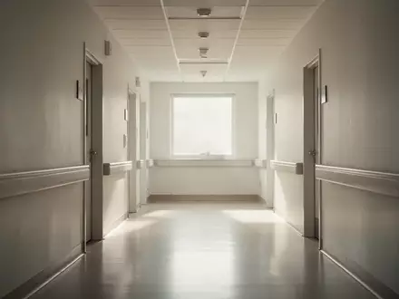 Ein leerer, sonnendurchfluteter Krankenhausflur mit minimalistischer Architektur und ruhiger, kontemplativer Atmosphäre. - Foto: über boerse-global.de