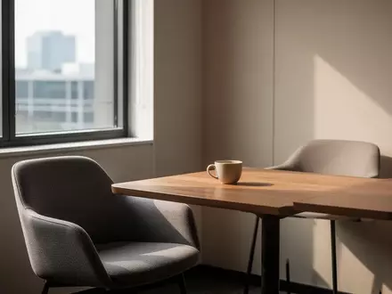 Ein minimalistischer Pausenraum mit einem leeren Becher auf einem Holztisch in einem hellen, ruhigen Bürogebäude. - Foto: über boerse-global.de