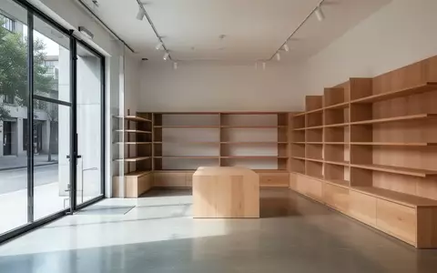 Ein minimalistisch gestalteter, leerer Verkaufsraum mit Holzregalen und Betonboden bei natürlichem Tageslicht. - Foto: über boerse-global.de