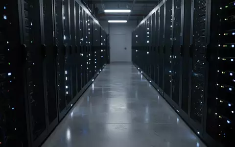 Dunkler, moderner Serverraum mit blau leuchtenden Statusanzeigen an unbeschrifteten Server-Racks. - Foto: über boerse-global.de