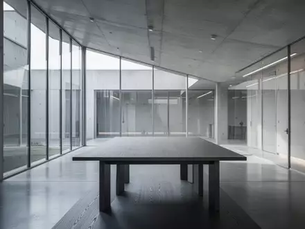 Ein minimalistischer, moderner Konferenzraum mit polierten Betonoberflächen und natürlichem Lichteinfall. - Foto: über boerse-global.de