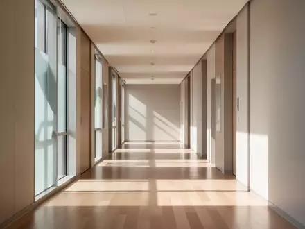 Ein heller, minimalistischer Flur in einem modernen Bildungszentrum mit natürlichem Lichteinfall und klaren Linien. - Foto: über boerse-global.de