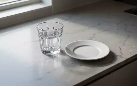 Ein minimalistisches, helles Kücheninterieur mit einem leeren Glas und einer Untertasse bei natürlichem Tageslicht. - Foto: über boerse-global.de