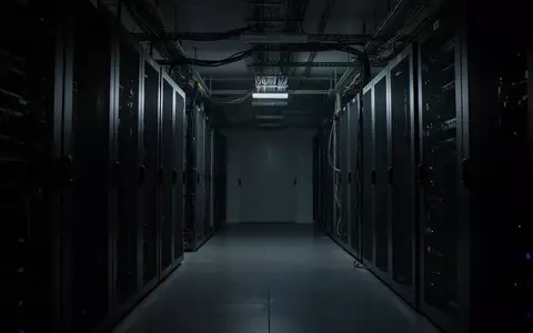 Dunkler, minimalistischer Serverraum mit metallischen Strukturen und Schatten in einer ruhigen, menschenleeren Umgebung. - Foto: über boerse-global.de