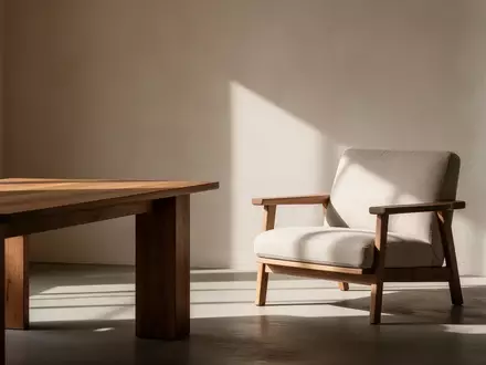 Ein helles, ruhig gestaltetes Zimmer mit einem Holztisch und einem Sessel in warmem Licht. - Foto: über boerse-global.de