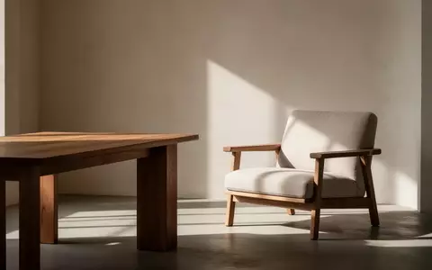 Ein helles, ruhig gestaltetes Zimmer mit einem Holztisch und einem Sessel in warmem Licht. - Foto: über boerse-global.de