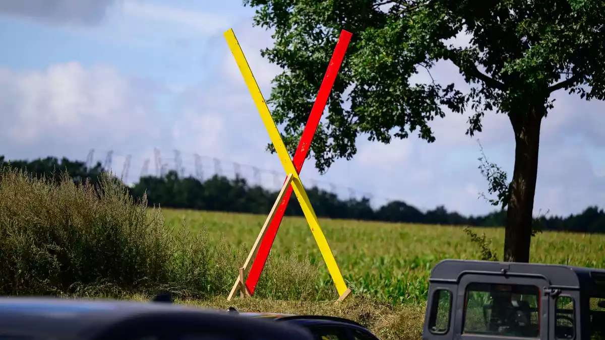 Die Neubaustrecke ist seit Jahren umstritten, auf diesem Hof steht ein Kreuz als Zeichen des Protests. (Archivbild) - Bild: Philipp Schulze/dpa