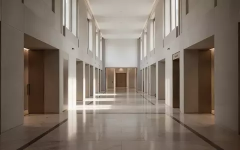 Ein minimalistischer, heller Flur in einem Regierungsgebäude mit polierten Steinböden und einfallendem Tageslicht. - Foto: über boerse-global.de