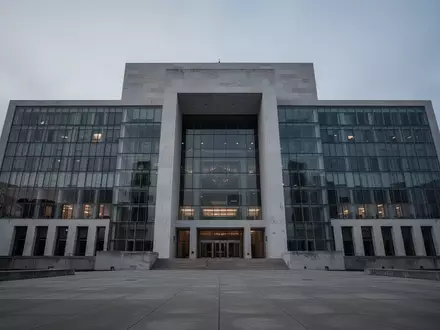 Ein modernes, imposantes Regierungsgebäude aus Glas und Beton in der Dämmerung. - Foto: über boerse-global.de