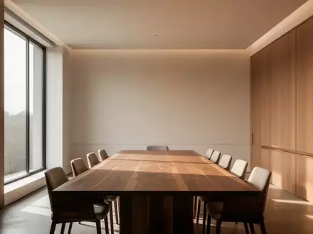 Ein minimalistischer, moderner Konferenzraum mit natürlichem Lichteinfall und einer leeren, polierten Holztischplatte. - Foto: über boerse-global.de