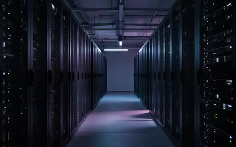Dunkler Serverraum mit beleuchteten Racks und abstrakten Lichtreflexen als Symbol für digitale Bedrohungen. - Foto: über boerse-global.de
