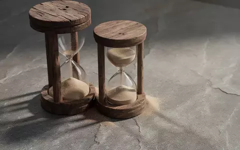 Ein Sanduhr-Symbol auf einem steinigen Untergrund, das den Zeitverlauf und kognitive Prozesse veranschaulicht. - Foto: über boerse-global.de