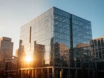 Moderne Glasfassade eines Bürogebäudes im Finanzviertel bei Sonnenuntergang. - Foto: über boerse-global.de