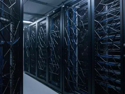 Ein minimalistischer, hochmoderner Serverraum mit ordentlich verkabelten Serverschränken in kühler, bläulicher Beleuchtung. - Foto: über boerse-global.de