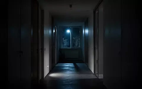 Ein dunkler, minimalistischer Flur bei Nacht mit kühlem Lichteinfall durch ein Fenster. - Foto: über boerse-global.de