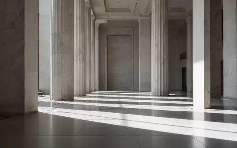 Innenansicht eines modernen Parlamentsgebäudes mit geometrischen Schatten und Marmorsäulen. - Foto: über boerse-global.de