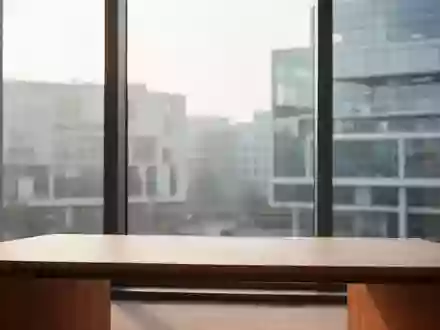 Ein minimalistisch eingerichtetes, helles Büro mit einem leeren Schreibtisch und Blick auf eine moderne Stadtlandschaft. - Foto: über boerse-global.de