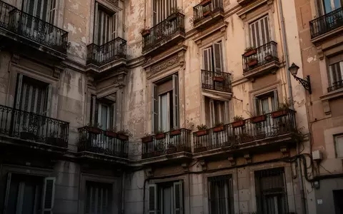 Die Fassade eines alten Wohnhauses im Madrider Stadtteil Retiro mit geschlossenen Fensterläden und schmiedeeisernen Balkonen. - Foto: über boerse-global.de