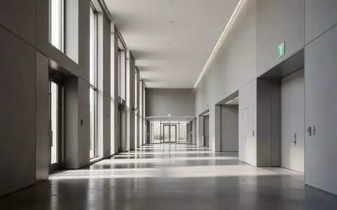 Ein minimalistischer, leerer Flur in einem modernen öffentlichen Gebäude bei Tageslicht. - Foto: über boerse-global.de