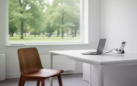 Ein minimalistischer, heller Behandlungsraum mit einem weißen Schreibtisch und einem Fenster mit Blick ins Grüne. - Foto: über boerse-global.de