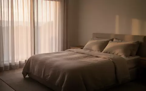 Ein minimalistisch eingerichtetes Schlafzimmer in den frühen Morgenstunden mit sanftem, natürlichem Licht. - Foto: über boerse-global.de