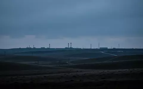 Eine weitläufige, einsame Landschaft nahe einer militärischen Einrichtung in der Dämmerung, die Ruhe und Schwere ausstrahlt. - Foto: über boerse-global.de