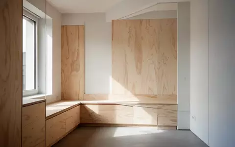 Minimalistischer, lichtdurchfluteter Wohnraum mit maßgefertigten Holzeinbauten und klaren architektonischen Linien. - Foto: über boerse-global.de