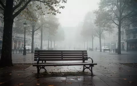 Eine leere Parkbank auf einem öffentlichen Platz bei nebligem Wetter, die eine Atmosphäre von Isolation und Melancholie vermittelt. - Foto: über boerse-global.de