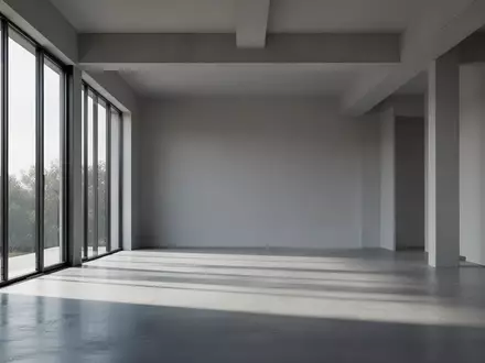 Ein minimalistischer, moderner Innenraum mit klaren architektonischen Linien und natürlichem Lichteinfall auf einem Betonboden. - Foto: über boerse-global.de