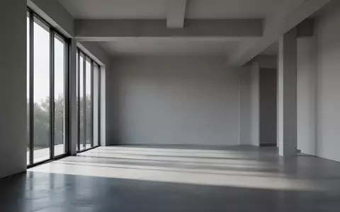 Ein minimalistischer, moderner Innenraum mit klaren architektonischen Linien und natürlichem Lichteinfall auf einem Betonboden. - Foto: über boerse-global.de
