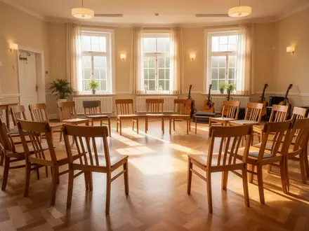 Ein heller, freundlicher Gemeinschaftsraum mit einem Stuhlkreis und Musikinstrumenten im Hintergrund. - Foto: über boerse-global.de