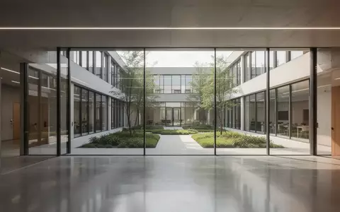 Ein modernes, minimalistisches Universitätsgebäude mit polierten Betonböden und großen Glasfronten bei natürlichem Tageslicht. - Foto: über boerse-global.de