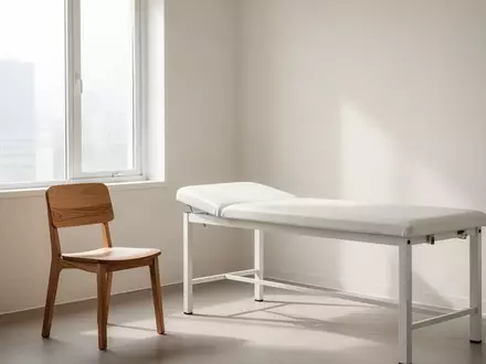 Ein heller, minimalistischer Behandlungsraum in einer Klinik mit einem leeren Stuhl und einer Untersuchungsliege. - Foto: über boerse-global.de