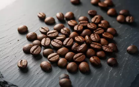 Nahaufnahme von gerösteten Kaffeebohnen auf einer dunklen Schieferoberfläche. - Foto: über boerse-global.de
