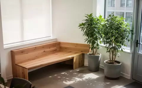 Ein heller, minimalistischer Pausenraum mit einer Holzbank und einer großen Pflanze, der eine ruhige Arbeitsumgebung symbolisiert. - Foto: über boerse-global.de