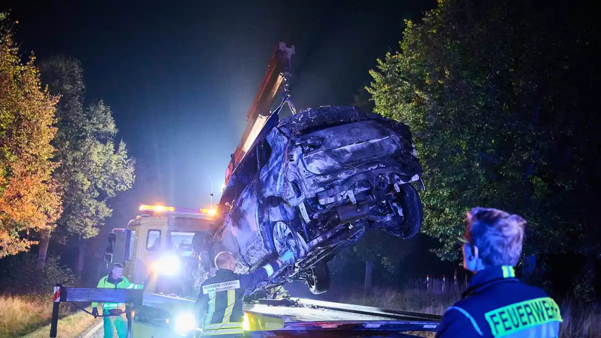 An der Unfallstelle wird das ausgebrannte Autowrack sichergestellt. - Bild: Annette Riedl/dpa