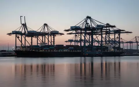 Ein moderner Industriehafen mit ContainerkrĂ€nen bei DĂ€mmerung als Symbol fĂŒr den deutschen AuĂenhandel. - Foto: ĂŒber boerse-global.de