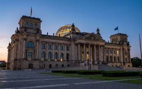 Die Architektur des Reichstagsgebäudes in Berlin während der Dämmerung mit Fokus auf die Steinfassade und die Glaskuppel. - Foto: über boerse-global.de