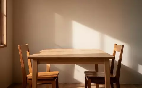 Ein minimalistisch eingerichteter Essbereich mit zwei gegenüberstehenden Stühlen an einem leeren Holztisch in hellem Tageslicht. - Foto: über boerse-global.de
